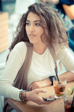 beautiful curly long brunette hair moroccan woman using smart ph