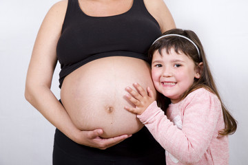 Little cute girl with her pregnant mother