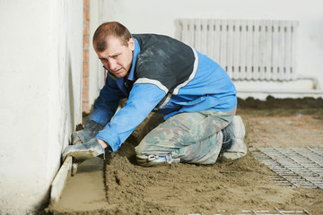 Plasterer concrete worker at floor work