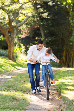 Father Teaching Daughter To Ride Bike