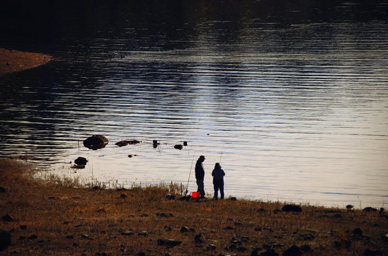 Two fishermen on the lake in the mountains in California.