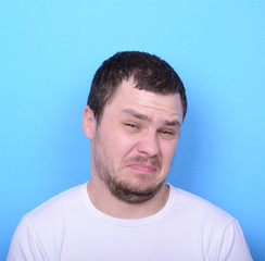 Obraz premium Portrait of man with dusgusted gesture against blue background