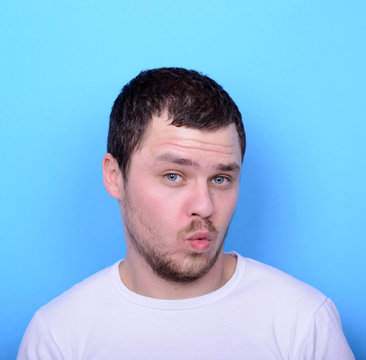 Portrait Of Man With Funny Face Against Blue Background