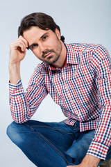 Handsome young man sitting on a wooden box