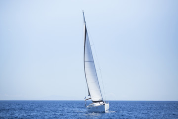 Fototapeta na wymiar Sailing ship yachts with white sails in the open sea.