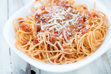 Glass plate with spaghetti bolognese, close-up, horizontal shot