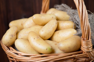 Wicker basket with raw potato, horizontal shot