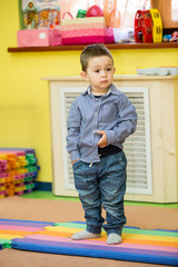 Little child boy playing in kindergarten in Montessori  Class.