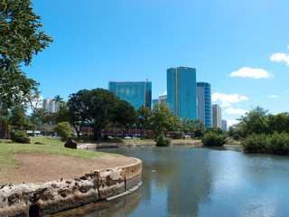 Naklejka premium Pond in Ala Moana Beach Park with Condominiums towers across the