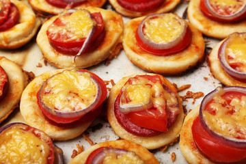 Small pizzas on baking paper close up