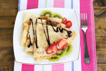 Delicious pancakes with strawberries and chocolate