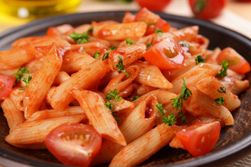 Pasta with tomato sauce on plate on table close-up