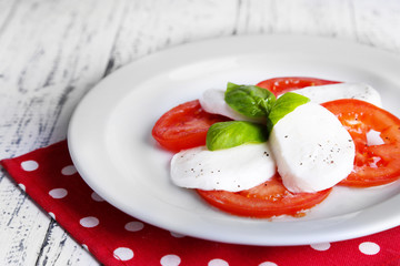 Caprese salad with mozarella cheese, tomatoes and basil