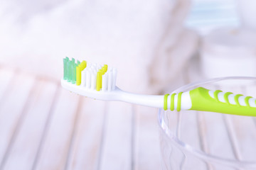 Fototapeta na wymiar Toothbrush in glass on table on light background