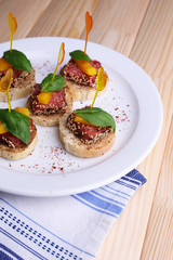 Tasty canapes with salami, pepper  and basil leaves,