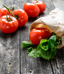 Tomatoes and salad on old grey wood