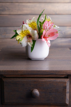 Fototapeta Alstroemeria flowers in vase on table on grey background