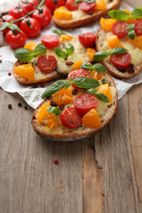 Tasty bruschetta with tomatoes, on old wooden table