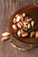 Fototapeta premium Tasty brasil nuts on salver, on wooden background