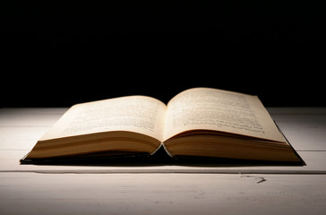 Old book on table on black background