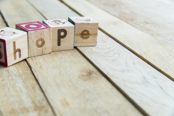 Wooden blocks are Hope word on wooden floor