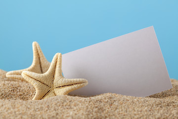 Fototapeta na wymiar Starfish and blank paper sheet on beach