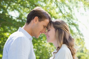 Attractive couple smiling at each other in the park