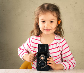 Little girl taking pictures with a vintage film camera.