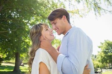 Cute couple hugging and laughing in the park