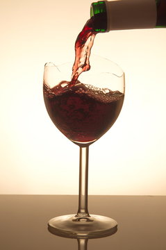 Pouring Red Vine Into A Broken Glass