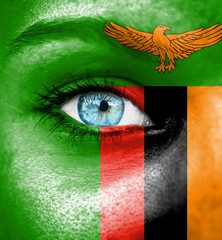 Woman face painted with flag of Zambia