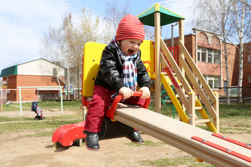 happy baby on seesaw outdoors