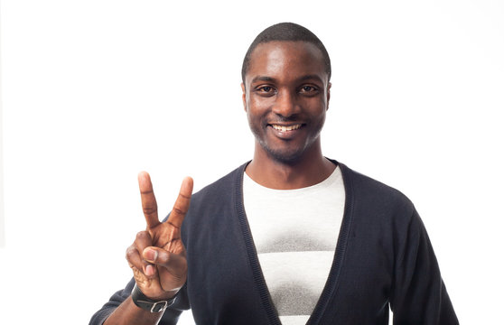 Casual dressed black man showing peace sign. Isolated on white.
