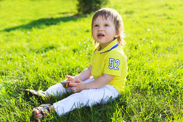 lovely baby sitting on grass in summer