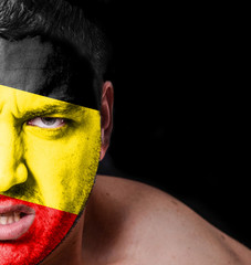Portrait of angry man with painted flag of Belgium
