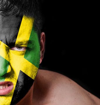 Portrait of angry man with painted flag of Jamaica