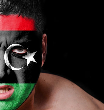 Portrait of angry man with painted flag of Libya