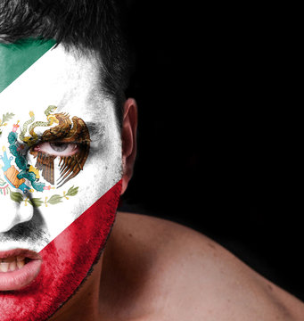 Portrait of angry man with painted flag of Mexico