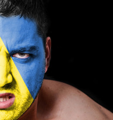 Portrait of angry man with painted flag of Ukraine