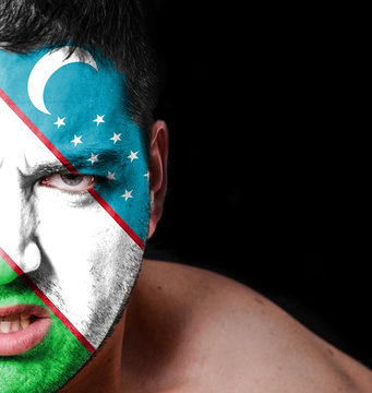 Portrait of angry man with painted flag of Uzbekistan