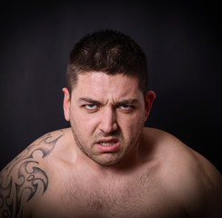 Obraz premium Portrait of angry man against dark background