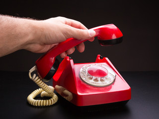 Red telephone handset in hand