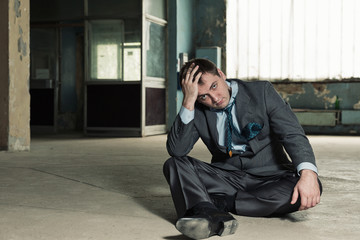 Poor businessman sitting on old cellar