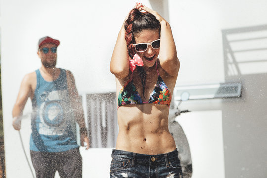 Man Pouring Water From A Hose Girl.