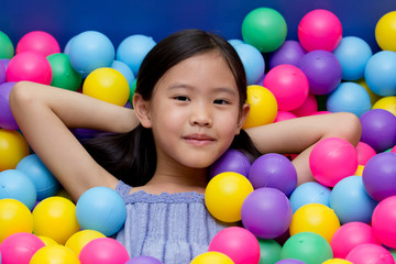 Fototapeta na wymiar Happy Asian child playing at kindergarten with colorful balls