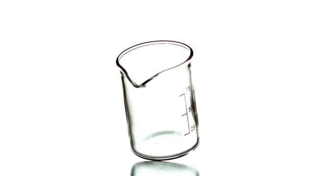 Empty beaker spinning on white background