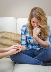 Hands of mother consoling sad teen daughter crying