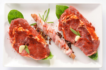 Raw fresh meat on board with condiments on white background