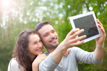 Young couple taking selfie picture at the park