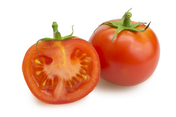 One whole tomato and one tomato slice with